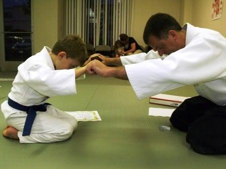 Instructor Ryan Goettsche Sensei in Colorado Springs awards a brown belt in Japanese Aikido to one of his students.