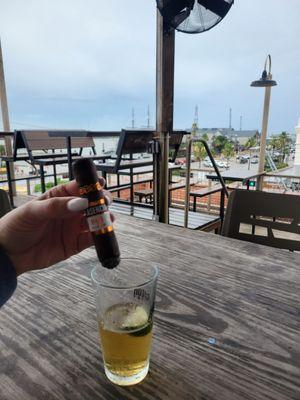 Customer enjoying a beer and cigar on the rooftop