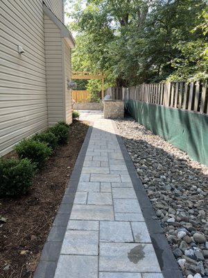 Paver path either border and river rock for water management. Also ran downspout underground.