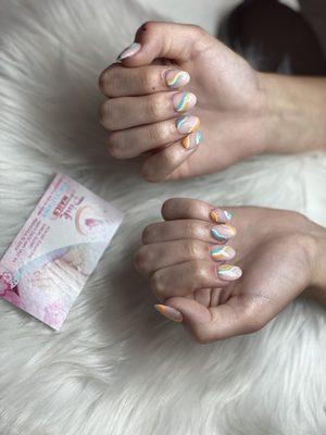 Round nails with orange white yellow and teal swirls