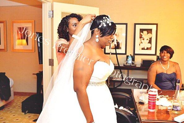 Helping place the veil onto the bride so it can flow beautifully behind her.