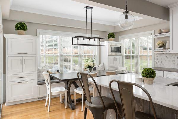 Custom breakfast nook window seat with storage and surround cabinetry