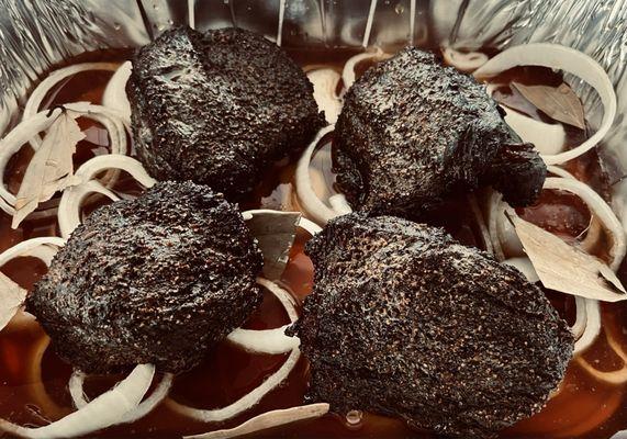 Braising beef cheeks in onions, bay leaves and beef stock to make barbacoa!