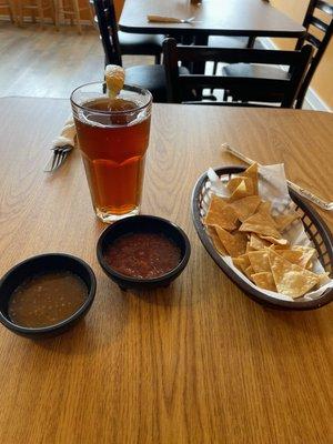 Chips, red and green salsa, and iced tea.