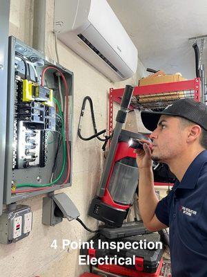 Home Inspector inspecting the electrical panel as part of the 4 point inspection.