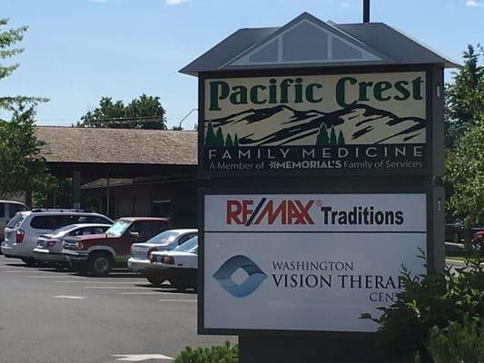 View of road sign and bank in the background, when arriving from the north on 72nd Ave.