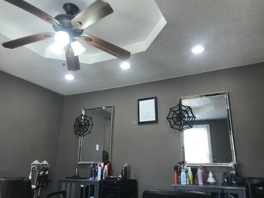 LED can lights positioned over booth chairs at a local hair salon.