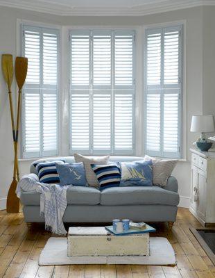 Custom color hinged wood shutter in living space.