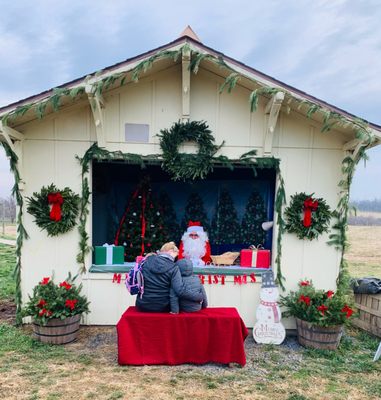 Santa having a socially distanced visit with a sweet little one.