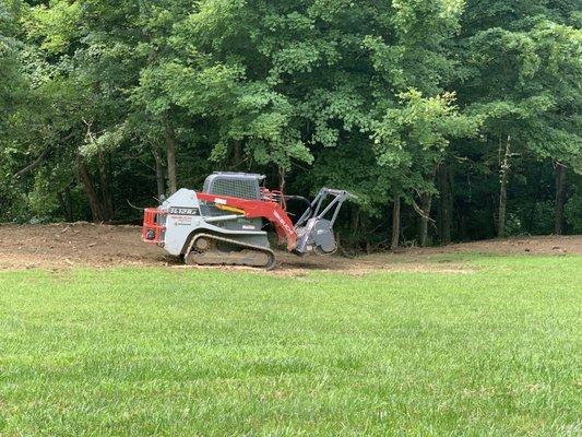 The rotating drum shreds undergrowth and fallen trees.
 He can shred logs Into woodchips.