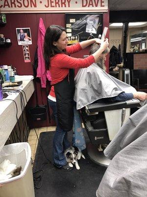 Chewy found a nice, safe place to rest on Jackie's feet as she cuts hair!