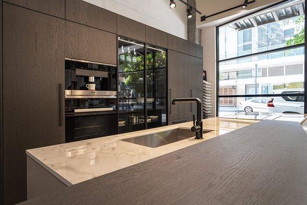 Pedini oak veneer tall cabinet units, countertop Dekton in Bergen Stonika, Miele appliances