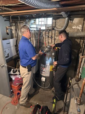 John Luke and his apprentice installing a water heater