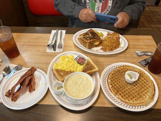 Eggs, grits, and waffle breakfast.