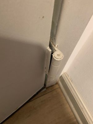 Door falling from hinges because it was not installed with all screws in place.