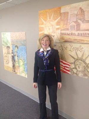 Laura in front of our custom made artwork echoing the principles of liberty, freedom, and justice.