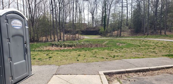 Same porta potty, lol. View of stairs next to what look like wooden bleachers. Guessing the high school field has access here.