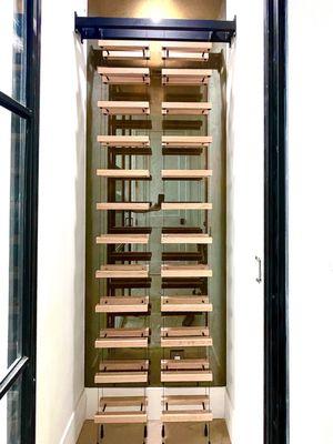 Installation and custom fabrication of cable suspended wine rack.