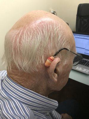 Ear gear keeps hearing aids dry and  is available in neutral or vibrant color choices. This man is not afraid of color or style!