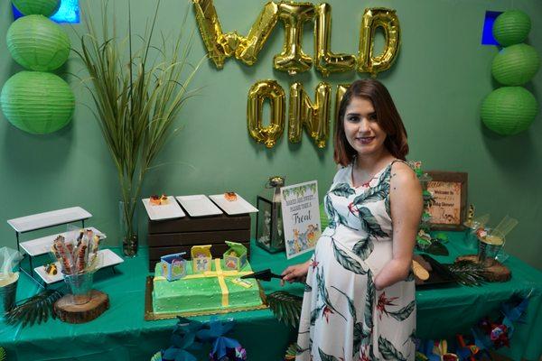 Mom to be cutting the cake at her custom "sweet treats" table.