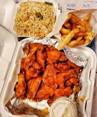 The whole spread featuring hot wings, French fries, and a side of veggie fried rice