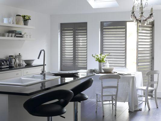 Custom color hinged wood shutters in kitchen.