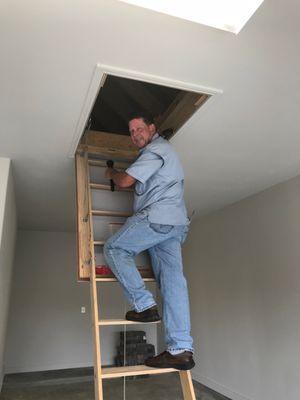 Climbing up into the attic during a home inspection.