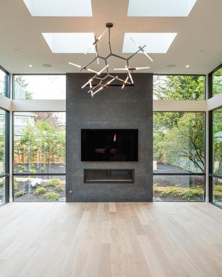 Spacious living room and fireplace in custom Bellevue home. Floor-to-ceiling windows and expansive living space.