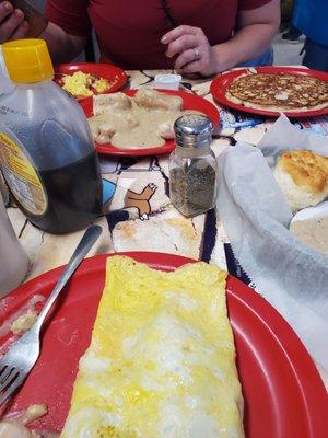 Sausage and cheese omlette, biscuits and gravy, and a pancake .