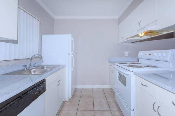 kitchen with white cabinetry, refrigerator, and stove