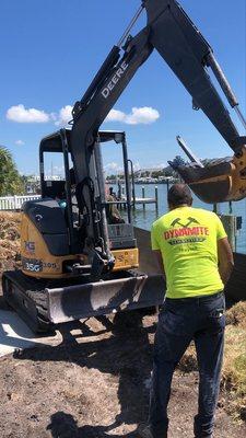 Using an excavator to haul a concrete column.