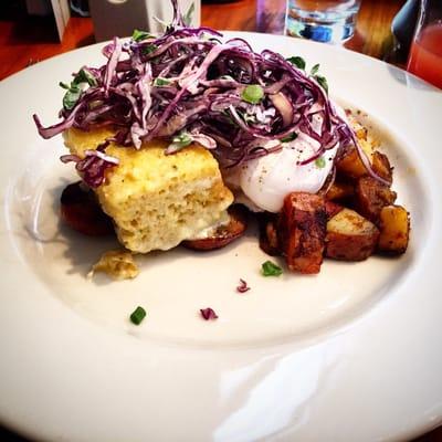 Brunch dish with toasted cornbread, spicy slaw, kielbasa, poached eggs and home fries