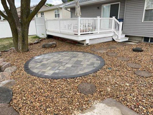 Circular paver patio within rock bed in Crete, NE.