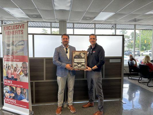 Chad and Eric Feyer, owners with a plaque presented from Ford for 25 years of operation.