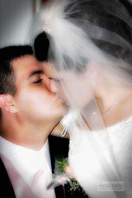 Wedding photography. Bride and groom kiss.