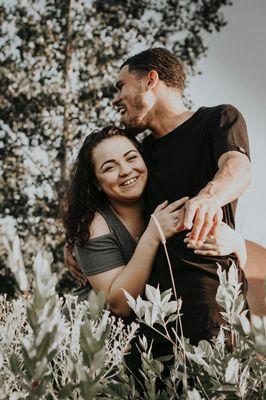 Photo of a couple laughing outdoors.