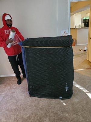 One of our crew members is preparing this dresser for transport with our thick furniture pads.