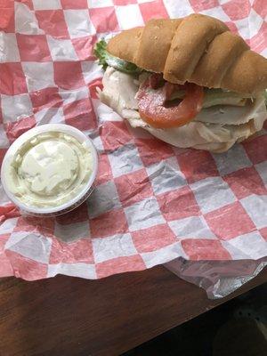 Turkey and cheese lettuce tomato onion on a croissant roll.