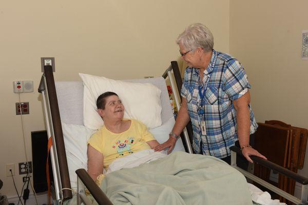 A volunteer talks with a patient at the Blue Water Hospice Home.