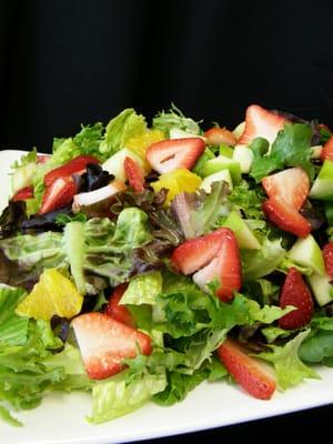 Spring salad with fresh apples, oranges and strawberries, with raspberry vinaigrette