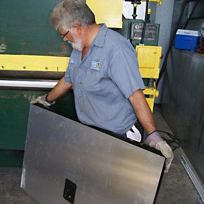 North Trail RV Collision Center RV technician holding finished fabricated RV part in Fort Myers, Florida.