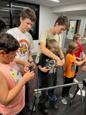 Expedition Rangers helping the younger boys with archery.