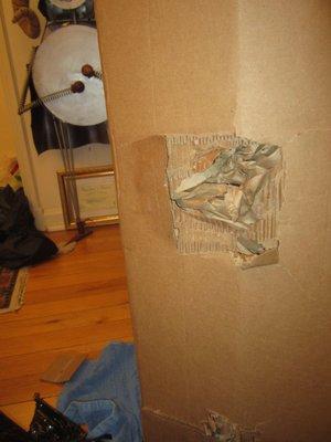 Huge holes/crushing  in cardboard box containing 200 lb column piece, NAVIS packing's cardboard box upon delivery!