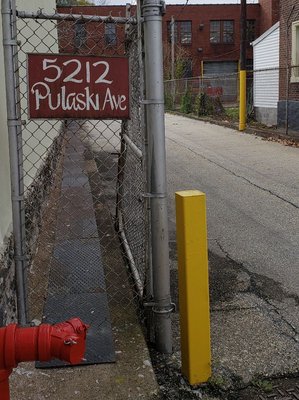 The building is in a residential area with the entrance being down a driveway between houses.