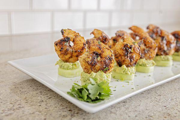 Grilled seasoned shrimp on cucumber with creamy avocado