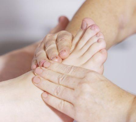 Reflexes on the feet being worked to help the body relax and naturally heal.