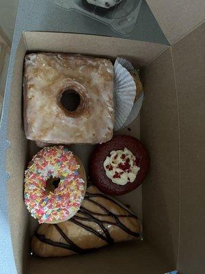 Cronut, red velvet donut with cream cheese frosting, raised donut with white frosting and sprinkles, Balinka and baklava.