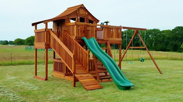 Fort Stockton swing set with wrap around deck, half shack, boardwalk, slide, climbers and playset accessories.