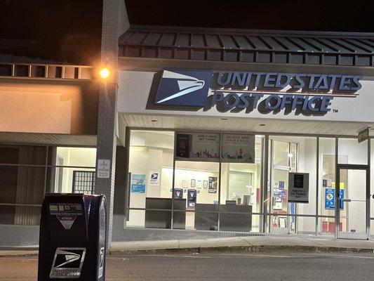 The front of the post office with an outside mail box in front of it.