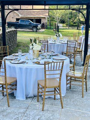 Round tables, linens, chairs, chargers, glasses, cutlery, and napkins all provided by encore